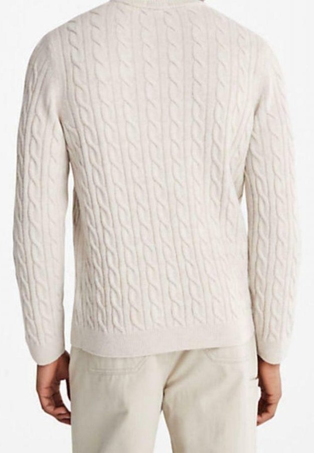 Homme portant un pull en maille torsadée de couleur crème et un pantalon beige clair, vu de dos.