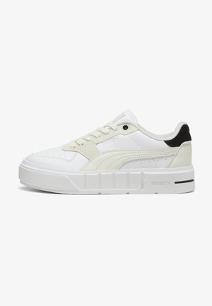 Witte sneakers met een gestructureerd ontwerp, voorzien van bovenwerk van glad leer, geperforeerde teenbox, contrasterende zwarte hak en dikke witte zool.