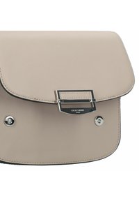 Beżowa skórzana torebka na ramię z klapką, srebrnymi akcentami i detalem z logo. Gładka tekstura z prostym designem i kontrastowym przeszyciem.