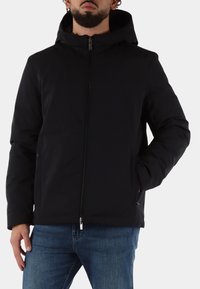 Zwarte jas met capuchon en een ritssluiting aan de voorkant, met een gladde textuur en een aansluitend ontwerp. Zichtbare zijzakken en stevige stiksel details.