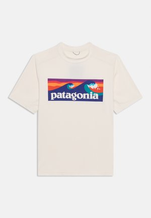 Bílé tričko s krátkým rukávem s barevným obdélníkovým motivem stylizovaných vln a nápisem "patagonia" přes hrudník.