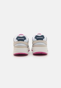 Baskets de sport blanches et beige avec des semelles roses, tige en maille et accents navy. Dotées d'un col et d'un talon rembourrés pour le soutien.