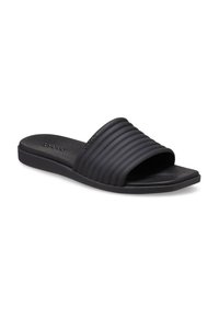 Black slide sandal featuring a textured, ribbed strap and a flat sole. Made of flexible material, with a simplistic design and no embellishments.
