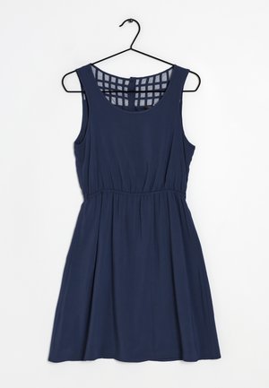 Sleeveless navy blue dress with gathered waist and square mesh back detail, hanging on a black hanger against a white background.