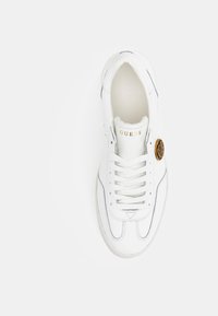 Sneaker bianco con tomaia in pelle liscia, cuciture a contrasto, punta rotonda, chiusura con lacci e un dettaglio del logo dorato sul lato.