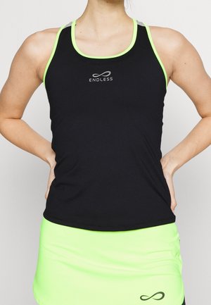 Atlet iført sort tanktop med grøn kant og matchende lysegrøn nederdel med "Endless" logo på toppen og uendelighedssymbol på nederdelen.