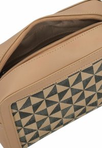 Bolso sintético en tono beige con un patrón triangular geométrico en negro y beige, con cierre de cremallera y acentos de tela texturizada.