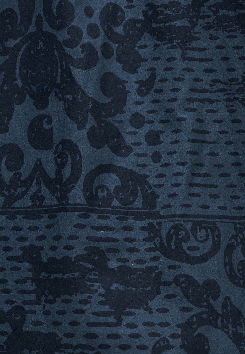 Tessuto blu scuro con motivi damascati neri e punti sparsi che creano un disegno ornamentale strutturato.