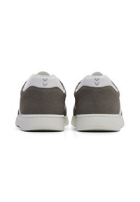 Gray suede sneakers with white accents, featuring a textured sole and chevron design on the heel. Minimalist low-top silhouette.