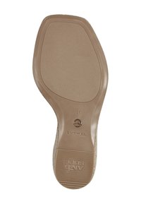 Suola delle scarpe in gomma beige con grip testurizzato, contrassegnata dal logo del brand "Toms" e dalla taglia 37. Tacco arrotondato con bordi curvi e superficie liscia.