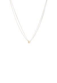Collar de plata de doble cadena con una pieza de acento dorado en el centro. El diseño incluye un acabado suave y pulido.