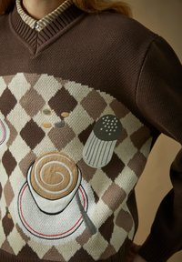 Brun argylegenser med brodert kaffekopp, skje, sølte kaffebønner og saltkvern på forsiden.