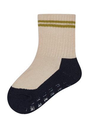 Beiger Socken mit olivgrünen Streifen am Bündchen und dunkelblauem Fersen-, Zehen- und Sohlenbereich mit rutschsicheren Griffen auf weißem Hintergrund.