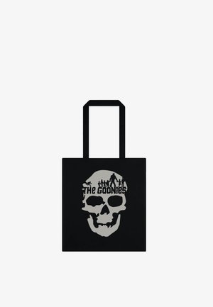 Czarna torba typu tote z dużą szarą grafiką czaszki i sylwetkami ludzi nad napisem "The Goonies."