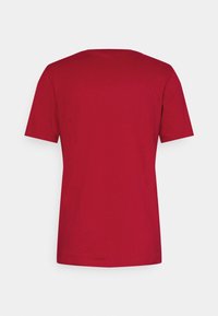 Camiseta roja de manga corta, hecha de suave tela de algodón, presenta un clásico cuello redondo y un diseño trasero limpio y sin adornos.