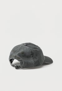 Tumehall puuvillane denimist pesuäriga baseball-susser, reguleeritava rihmaga ja metallist pandlaga, vaadates tagant lihtsal valgel pinnal.