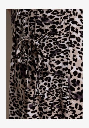 Tela beige con manchas negras irregulares de leopardo, con un gran bolsillo y un detalle de presilla de cinturón atada.