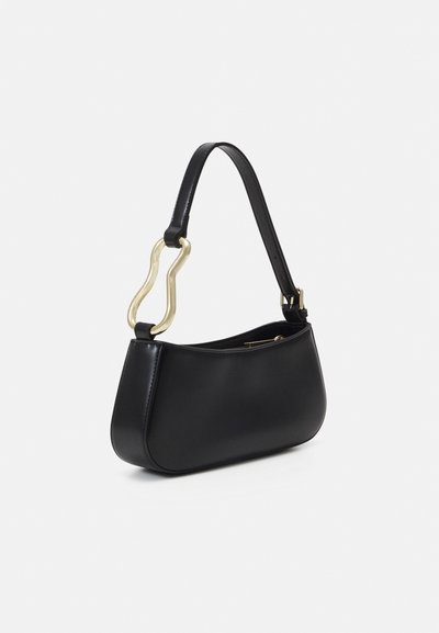 Borsa a mano in pelle nera con silhouette curvata, caratterizzata da un manico distintivo in tonalità oro e un design elegante. Texture liscia e stile minimalista.