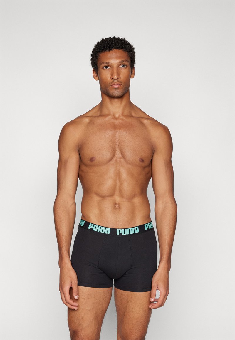 Black boxer shorts with a light blue PUMA logo waistband. Features a snug fit and soft texture, suitable for everyday wear.