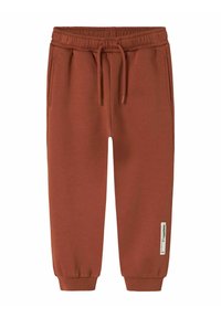 Rustfarvede sweatpants lavet af blødt stof. Har en elastisk talje, justerbar snøre og sidelommer. Cuffede ankler.