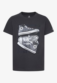 Črna bombažna majica s sivimi grafičnimi podrobnostmi čevljev Converse z belimi detajli, zasnovana z okroglim izrezom in kratkimi rokavi.