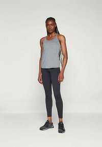 Grå treningstopp, svarte leggings og svarte joggesko; strømlinjeformet design med minimale mønstre; tettsittende silhuett og pustende stoff.