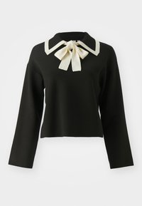 Pull cropped noir avec un col Peter Pan blanc et un détail de nœud. Le design possède des manches longues et une texture lisse.