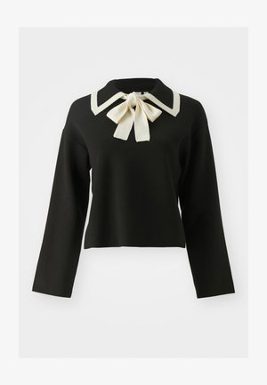 Svart kortärmad tröja med en vit Peter Pan-krage och detaljer med fluga. Designen har långa ärmar och en mjuk textur.