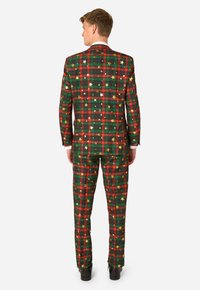 Rot-grünes kariertes Anzug mit goldenen Sternelementen. Verfügt über eine taillierte Passform, Reverskragen und gerade geschnittene Hosen. Glatter Stoff mit angenehmer Textur.