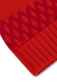 Rode gebreide muts met een houthakkerspatroon in donkerder rood, met een geribbelde onderrand. Zachte textuur en warm materiaal zijn zichtbaar.
