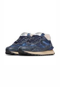 Un paio di sneakers blu navy con dettagli in pelle stropicciata, fodera in pelliccia color crema, suole beige e suole esterne nere e robuste.