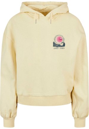 Geel, cropped hoodie met een trekkoord, met een grafisch ontwerp van een zon en golven, voorzien van de tekst "SUNSET CHARM" in donkere letters. Zachte textuur.