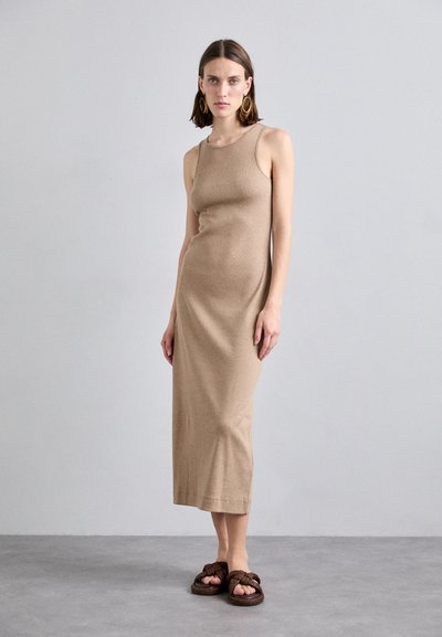 Abito midi senza maniche color beige in un tessuto morbido con una silhouette aderente. Abbinato a sandali intrecciati scuri. Tessuto semplice e liscio.