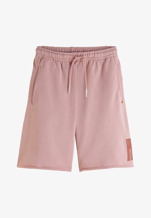 Pantalones cortos casuales de color rosa claro con cintura elástica, cordones ajustables, bolsillos laterales y una pequeña etiqueta rectangular cerca del dobladillo en la pierna derecha.