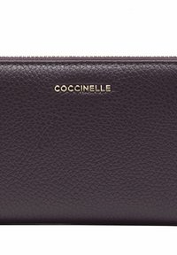Cartera de cuero morado oscuro con textura de grano, que presenta un logo dorado de "Coccinelle" en la parte frontal y un cierre de cremallera en el borde superior.