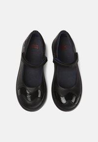 Czarne skórzane buty Mary Jane z błyszczącym czubkiem, falistym brzegiem i regulowanym paskiem; mają ciemnoniebieskie wkładki.