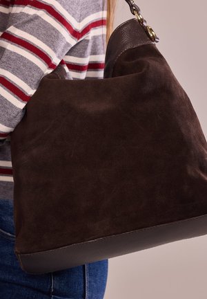 Sac à main en suede marron avec une bordure en cuir lisse sur le dessus, doté d'une bandoulière en chaîne et d'une base structurée. La texture semble douce et duveteuse.