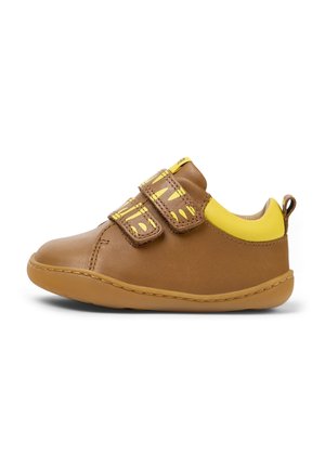 Chaussure marron pour tout-petit avec col rembourré jaune et deux bandes Velcro jaunes à motifs sur fond blanc.