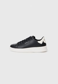 Black leather sneaker with white rubber sole, rounded toe, lace-up front, and subtle branding on the side and heel. Smooth texture with accents.