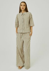 Beige striped two-piece outfit featuring a button-up shirt with a collar and wide-leg pants, crafted from lightweight fabric.