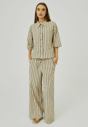 Beige gestreepte twee-delige outfit bestaande uit een knoopsluiting shirt met een kraag en brede broekspijpen, gemaakt van lichtgewicht stof.