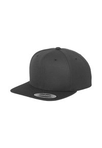 Black snapback cap with a flat brim, textured fabric, six-panel design, and eyelet vents, featuring a logo patch on the front.