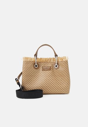 Bolso de paja tejido a rayas en tonos marrón y beige con un borde de flecos. Presenta herrajes circulares plateados y una correa negra desmontable.