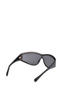 Černé sluneční brýle s štíhlým a ostrým designem. Tmavé čočky a lesklý plastový rám. Obsahují jemné detaily na pantě.