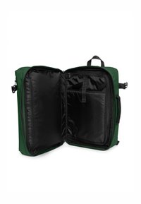 Zaino in tessuto verde con interno nero. Include due scomparti, uno con zip e una fascia elastica per una conservazione sicura.
