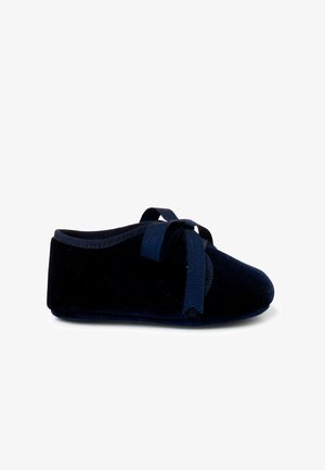 Chaussons de ballet en velours bleu marine avec un bout arrondi, une texture douce et des liens en ruban assortis sur le dessus pour un maintien sûr.