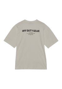 Jasnoszara bawełniana koszulka z krótkim rękawem. Czarne napisy na plecach brzmią "OFF DUTY GEAR" z dodatkowymi tekstami o mniejszej czcionce poniżej.