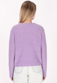Pulover lavandă cu un tricot moale și texturat. Dispune de un guler rotund, mâneci lungi și o croială lejeră. Este conceput cu un tiv scurt.