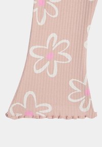 Różowa bluzka z półrękawami w kwiatowy wzór, z białymi konturami kwiatów i różowymi środkami, z prążkowaną teksturą i falbaniastym dołem dla dodatkowego efektu.