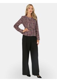 Fioletowa i wielokolorowa kurtka z tkaniny tweed, o dopasowanym kroju, długich rękawach i okrągłym dekolcie, zestawiona z czarnymi spodniami o wysokim stanie i szerokich nogawkach.